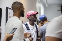 a group of people standing in a room talking to each other