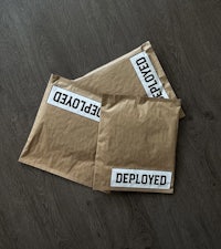 two brown mail bags with the word deployed on them