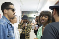 a group of people talking to each other in an art gallery