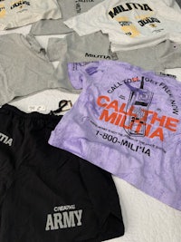 a group of t - shirts and shorts are laid out on a bed