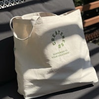 a tote bag with a green logo on it