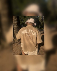 a man wearing a t - shirt with the word miltia on it